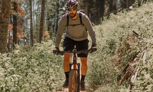 man riding a bike on a trail in the woods